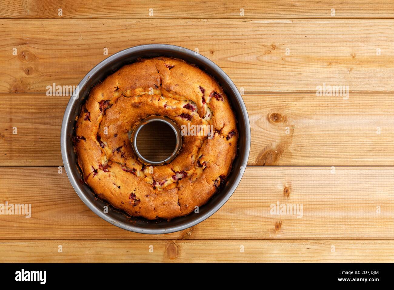 Frisch gebackener hausgemachter Himbeerkuchen in einer runden Metall-Backform auf Holztisch. Draufsicht. Copyspace. Stockfoto