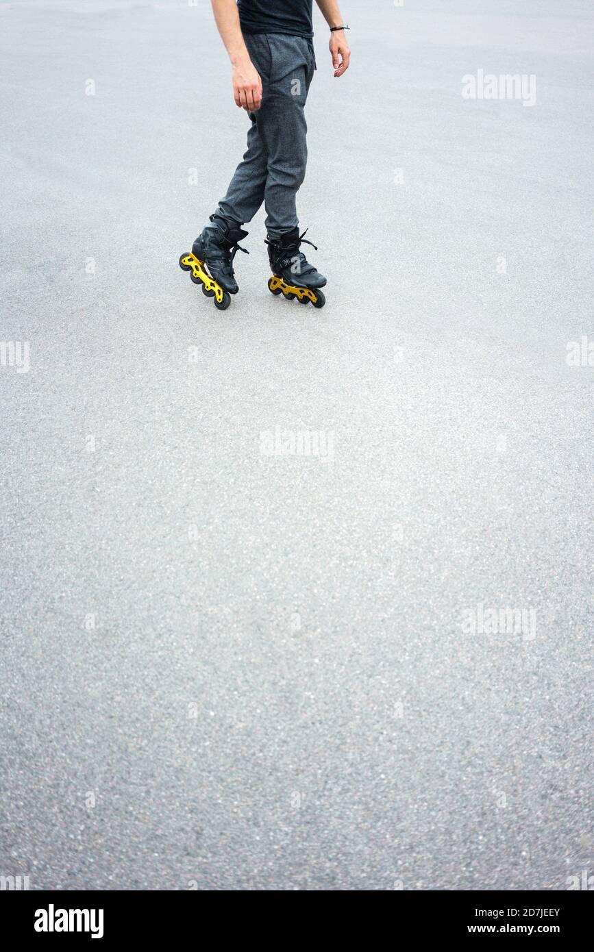 Beine von jungen Mann Inline-Skating auf der Straße Stockfoto