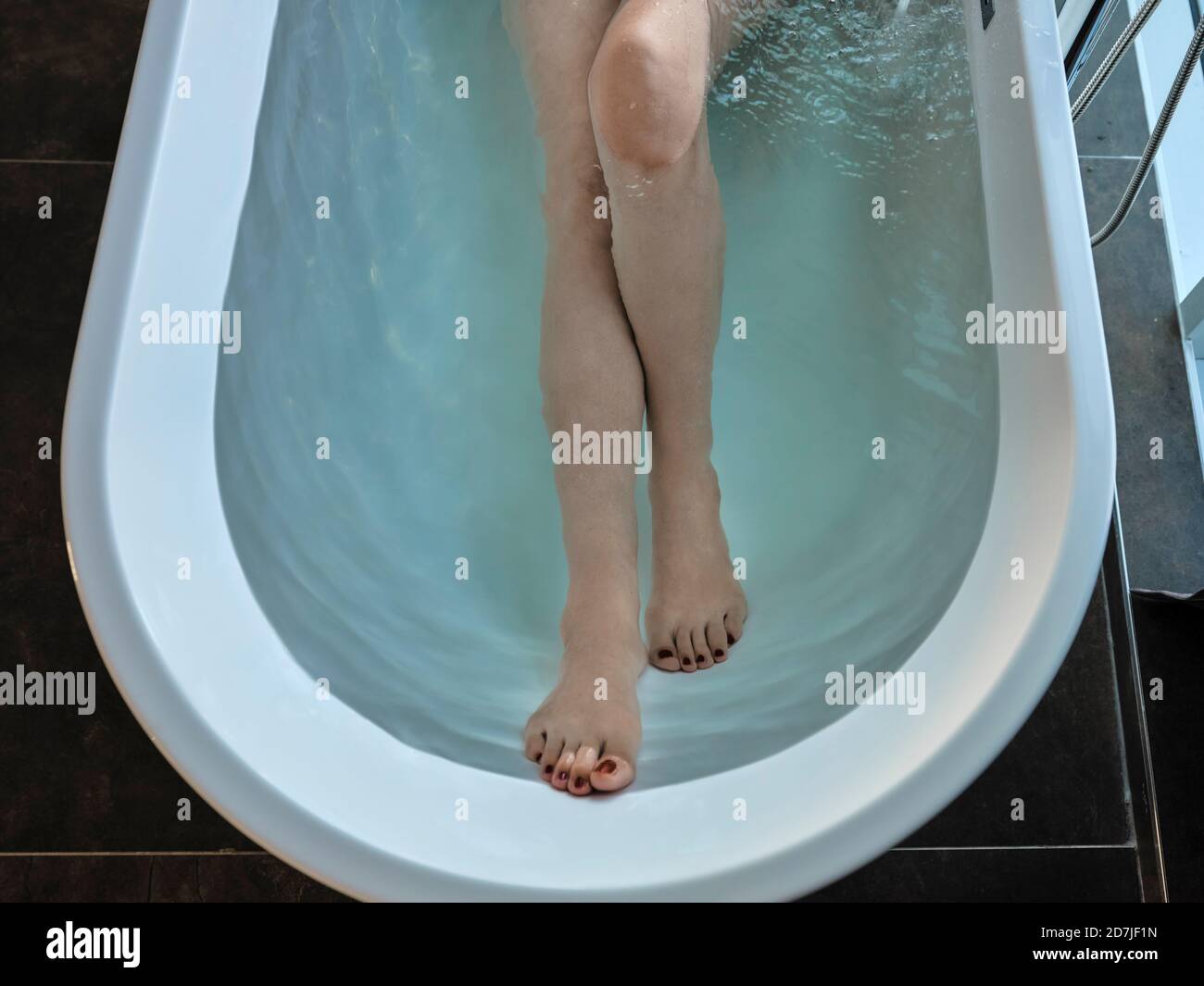 Ältere Frau, die in einem luxuriösen Hotelzimmer in der Badewanne baden kann Stockfoto
