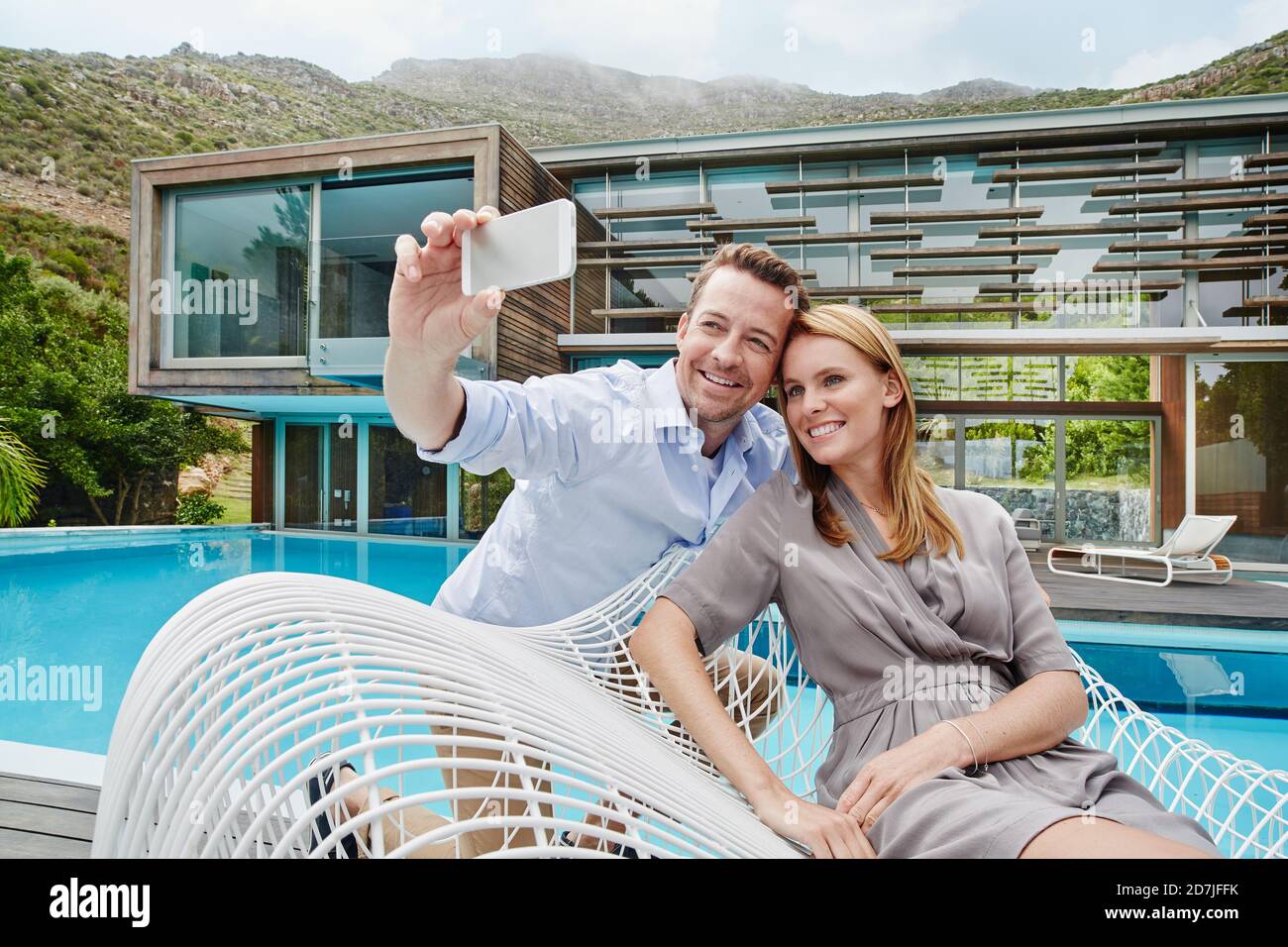 Paar Selfie auf dem Smartphone, während sie gegen Smart sitzen Telefon Stockfoto