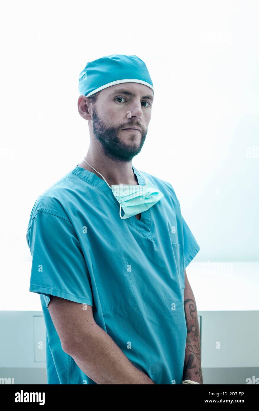 Sicherer männlicher Chirurg, der im beleuchteten Krankenhaus steht Stockfoto