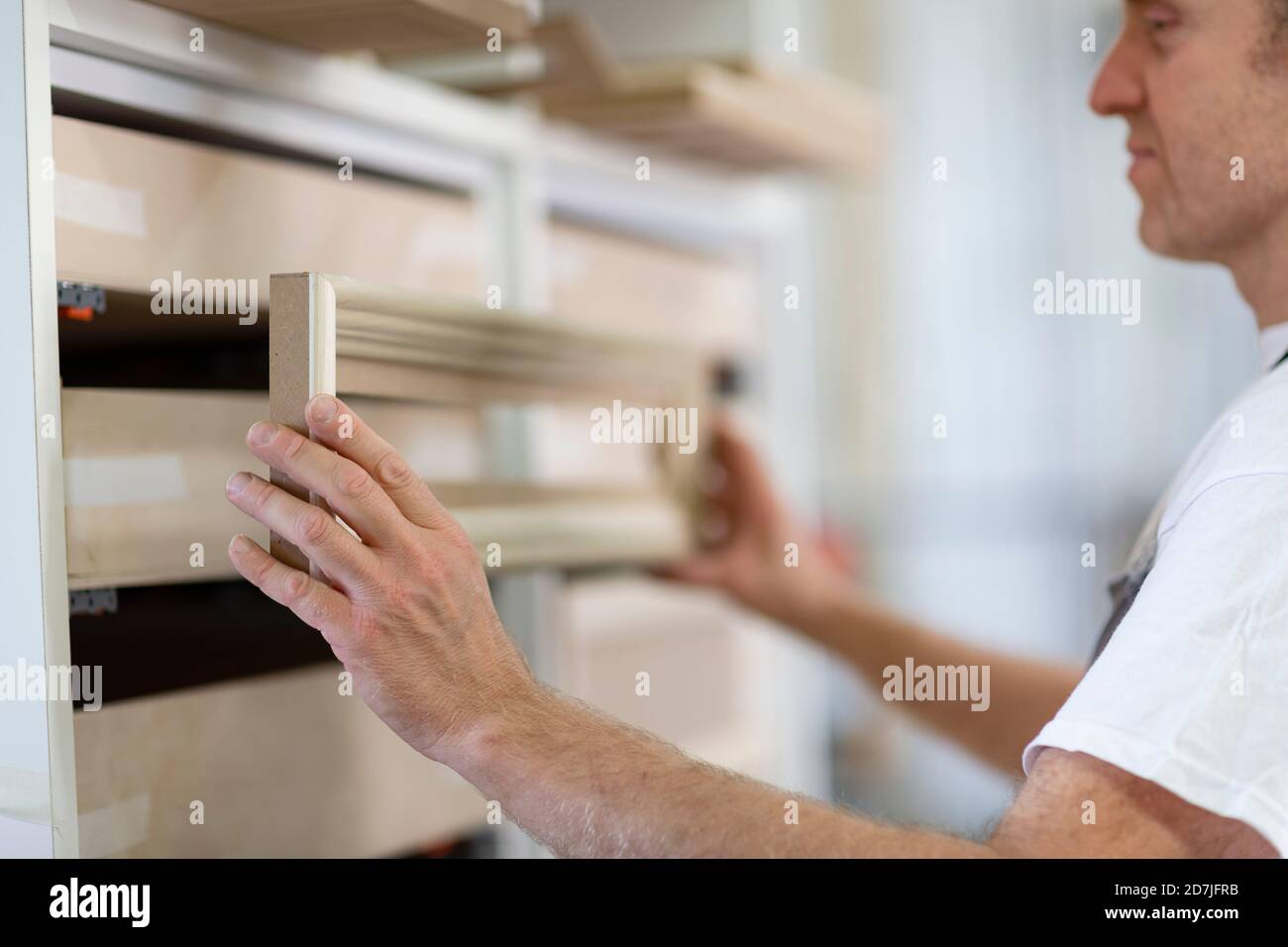 Mann, der in der Werkstatt stand und den Rahmen in die Schublade einpaste Stockfoto Mann, der in der Werkstatt stand und den Rahmen in die Schublade einpaste Stockfoto