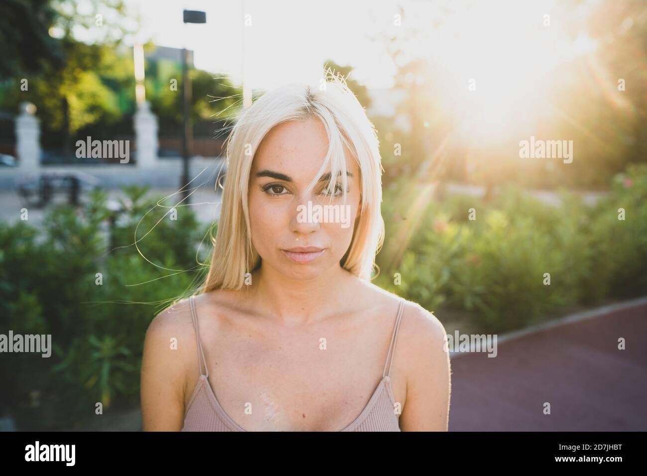 Nahaufnahme einer ernsthaften jungen Frau mit blonden Haaren im Park Bei Sonnenuntergang Stockfoto