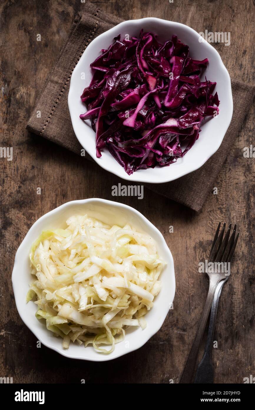 Schüssel mit rotem und weißem Kohlsalat auf dem Tisch Stockfoto