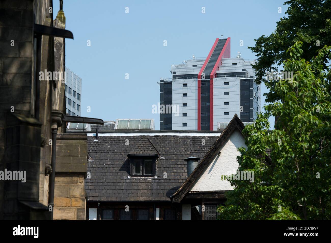 Hohes modernes Gebäude hinter der St. John the Evangelist's Church, Leeds, West Yorkshire, England. Stockfoto