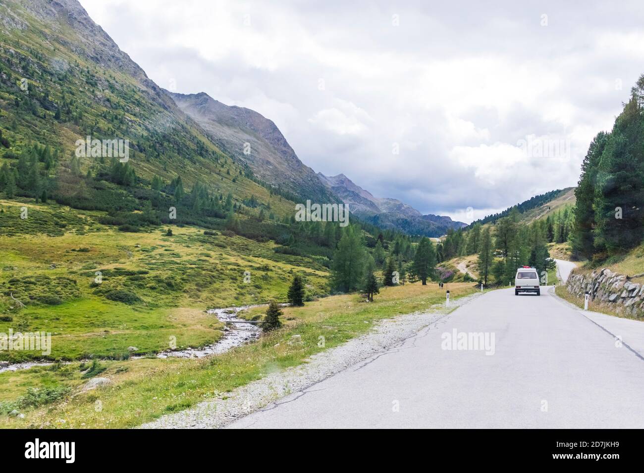 Auto auf der Straße in der Nähe der Bergkette gegen bewölkten Himmel an sonnigen Tagen, Sextner Dolomiten, Dolomiten, Südtirol, Italien Stockfoto