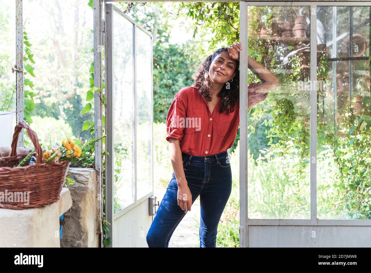 Frau, die sich an die Glastür im Hinterhof lehnt Stockfoto