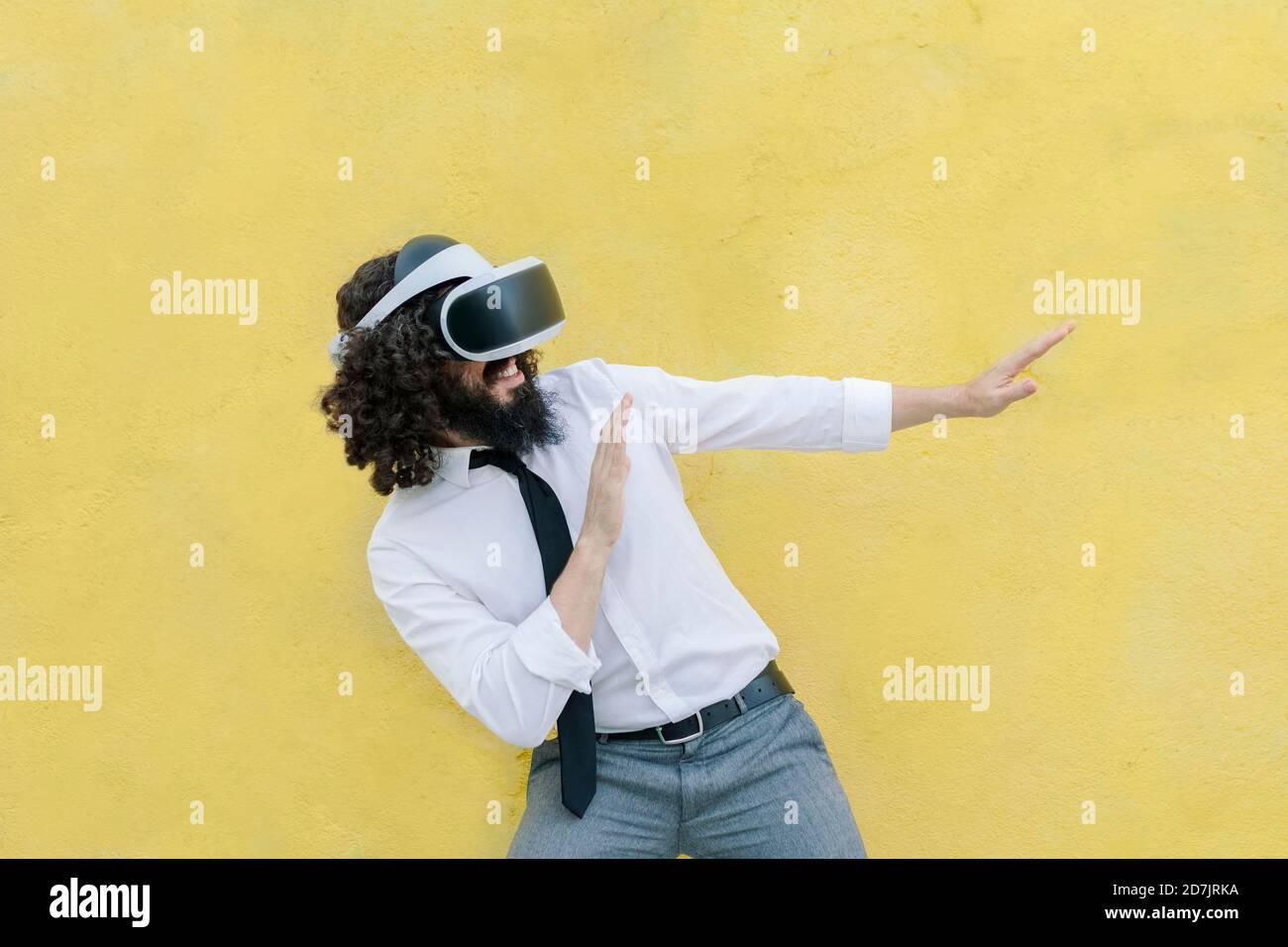 Mann trägt Virtual-Reality-Brillen gestikulierenden Stoppschild während des Stehens Gegen die Wand Stockfoto