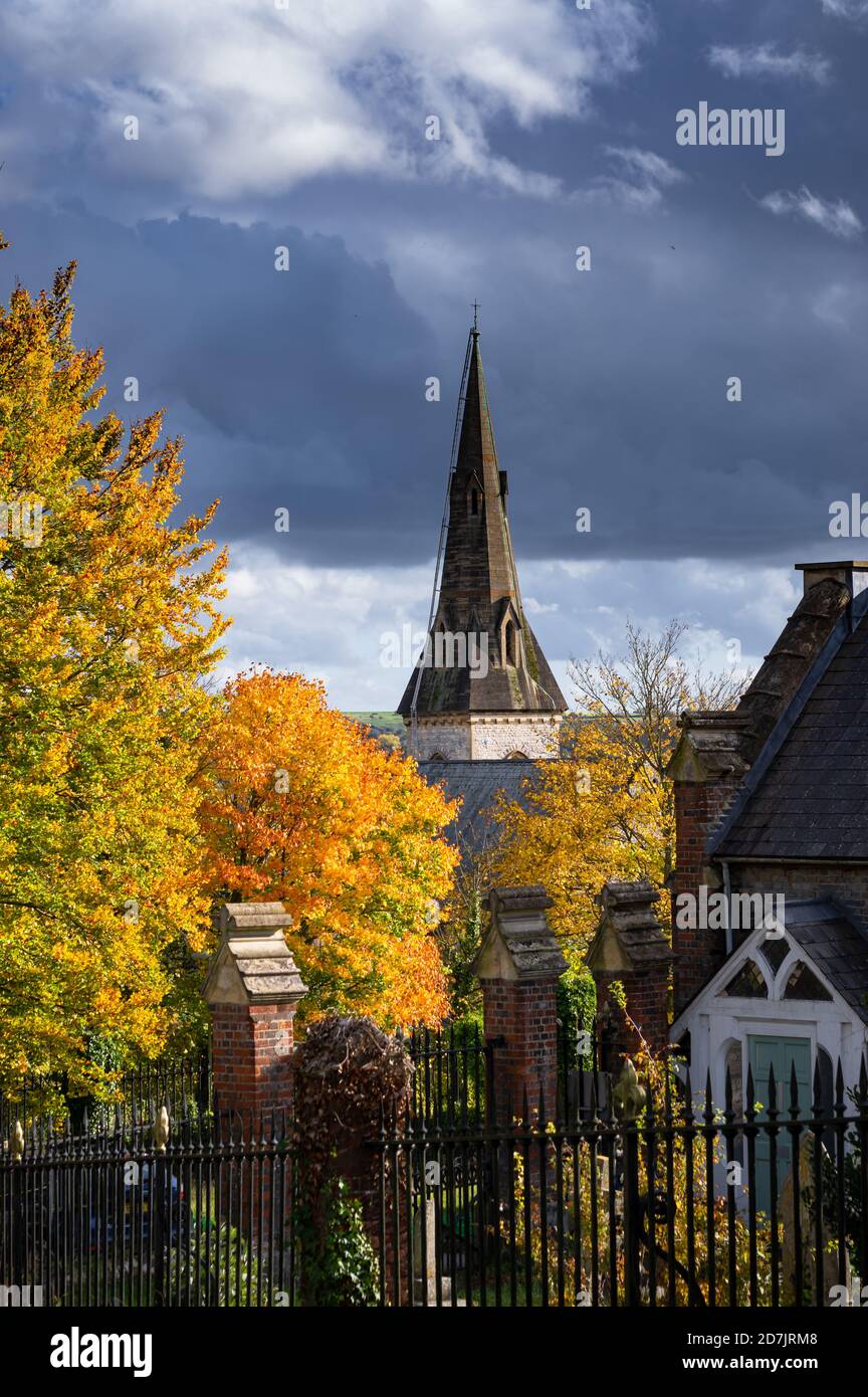 Ein Kirchturm erhebt sich über bunten Herbstblättern auf den Bäumen in Winchester, Hampshire, England. Stockfoto