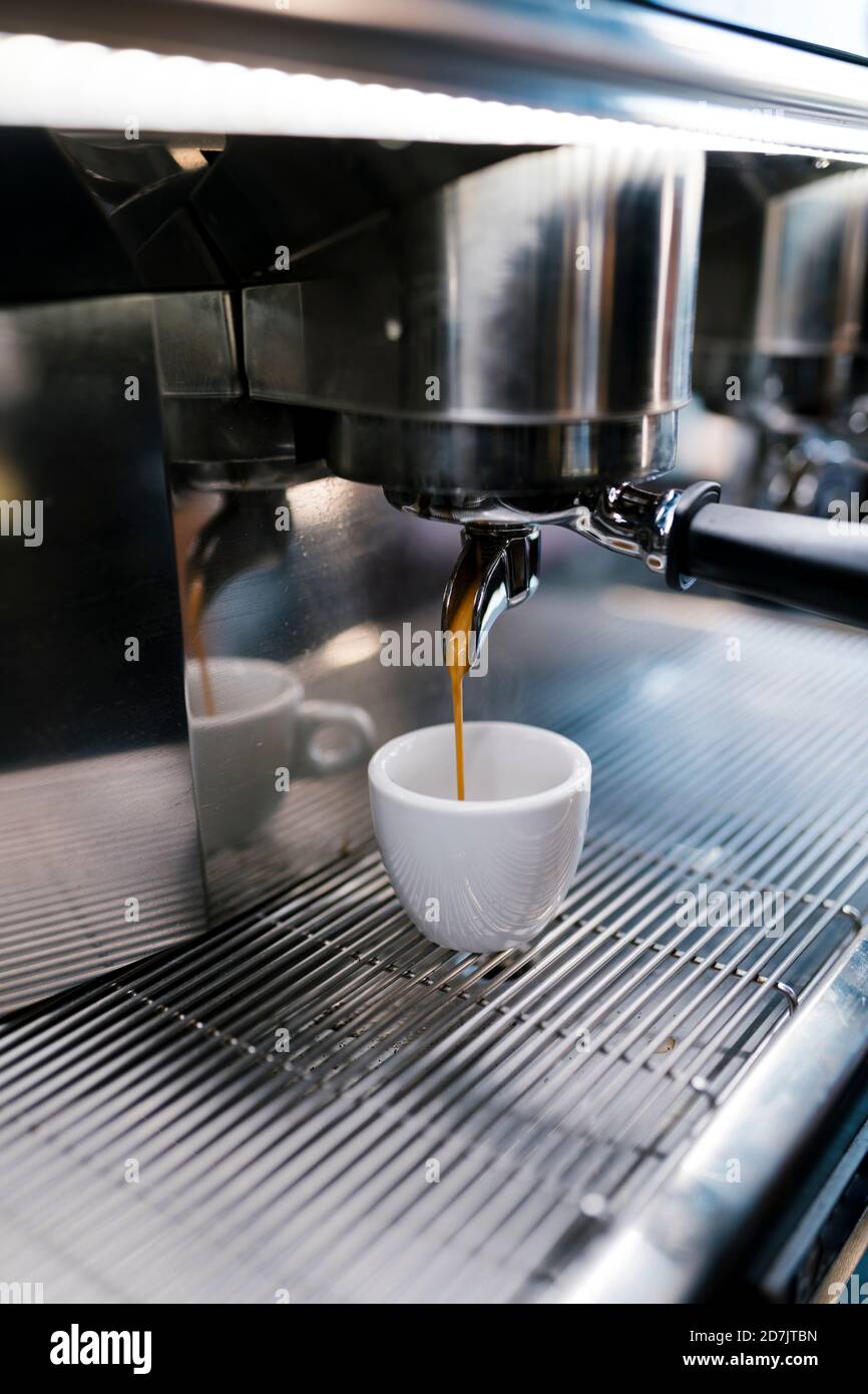 Kaffee wird in der Tasse durch die Maschinen im Café gegossen Stockfoto