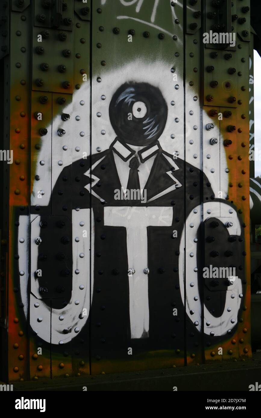 Graffiti auf einer Brückenkonstruktion in Mainz, Deutschland, zeigt einen Mann mit einer Vinylscheibe als Kopf und dem Schild 'UTC' Stockfoto