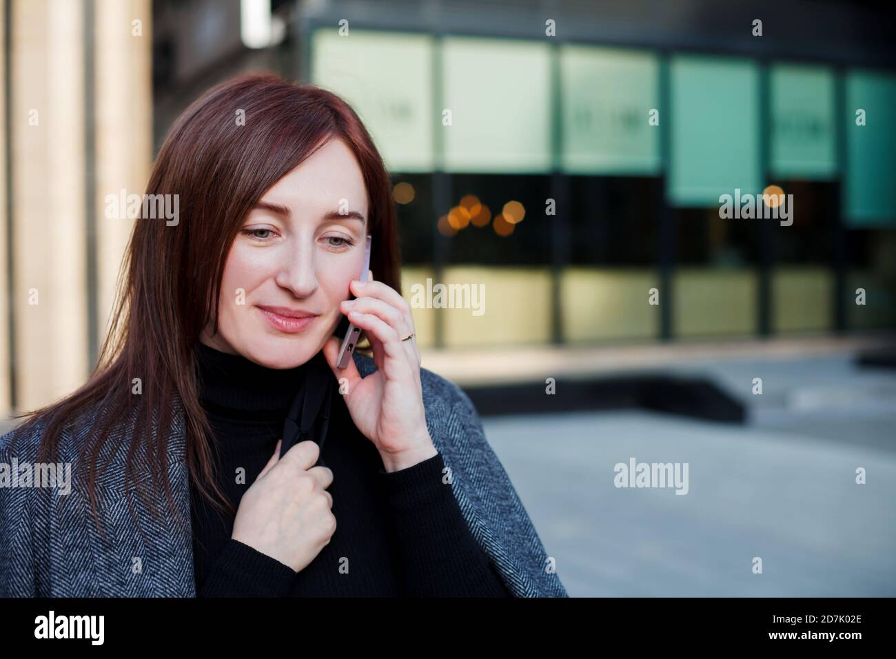 Geschäftsfrau, die in der Nähe ihres Bürogebäudes in der Innenstadt telefoniert. Geschäftskonzept. Stockfoto