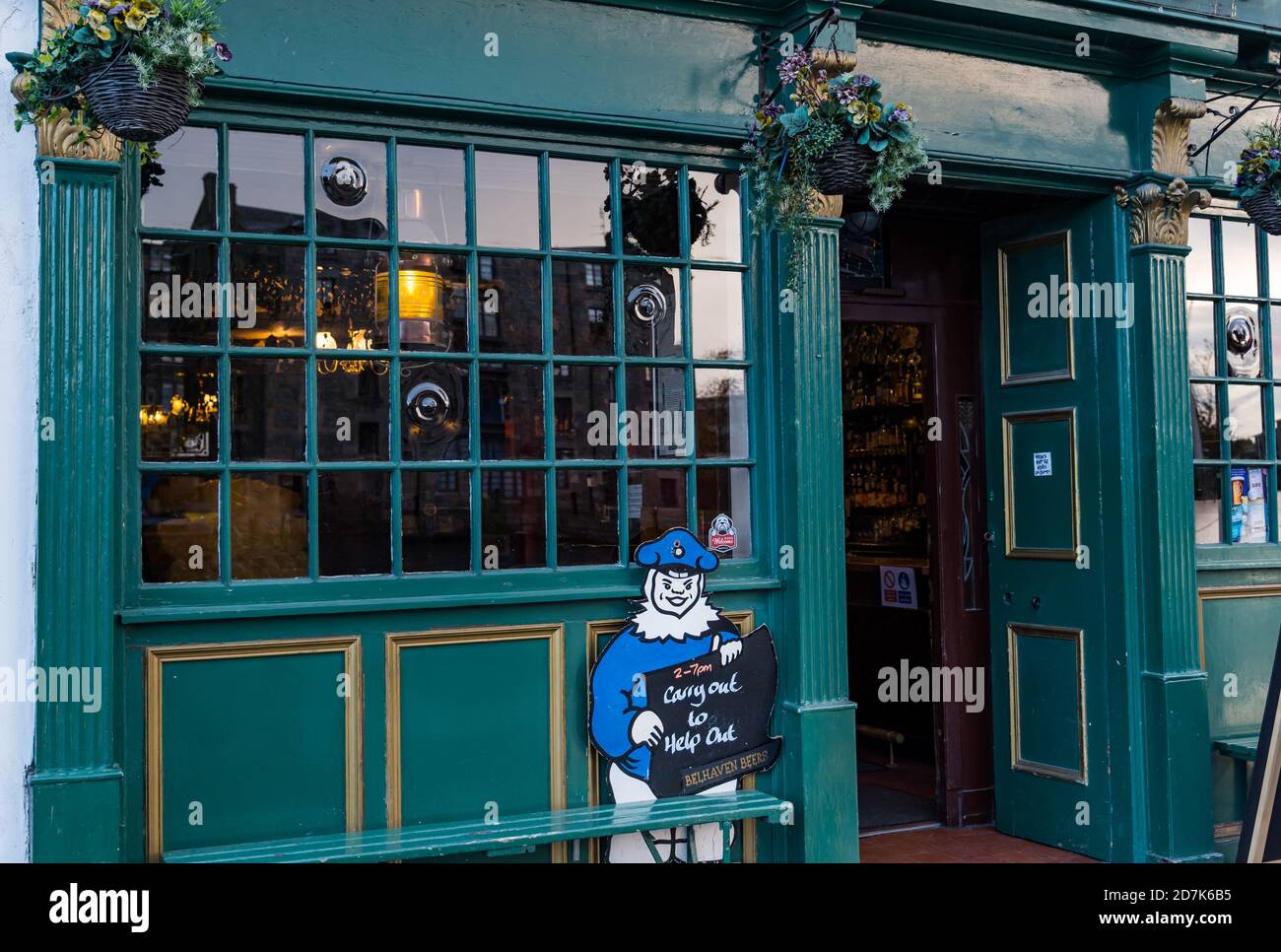 The Shore, Leith, Edinburgh, Schottland, Großbritannien, 23. Oktober 2020. Bars & Restaurants: Viele Restaurants sind geschlossen, da die schottische Regierung während der Covid-19-Pandemie die Beschränkungen für eine dritte Woche verlängert, aber viele sind noch offen und servieren Essen zum Mitnehmen und Bier. Der Pub Malt & Hops ist geöffnet für ein Bier zum Mitnehmen mit einer Zeichentrickfigur und dem Slogan „Carry out to help out“. Stockfoto