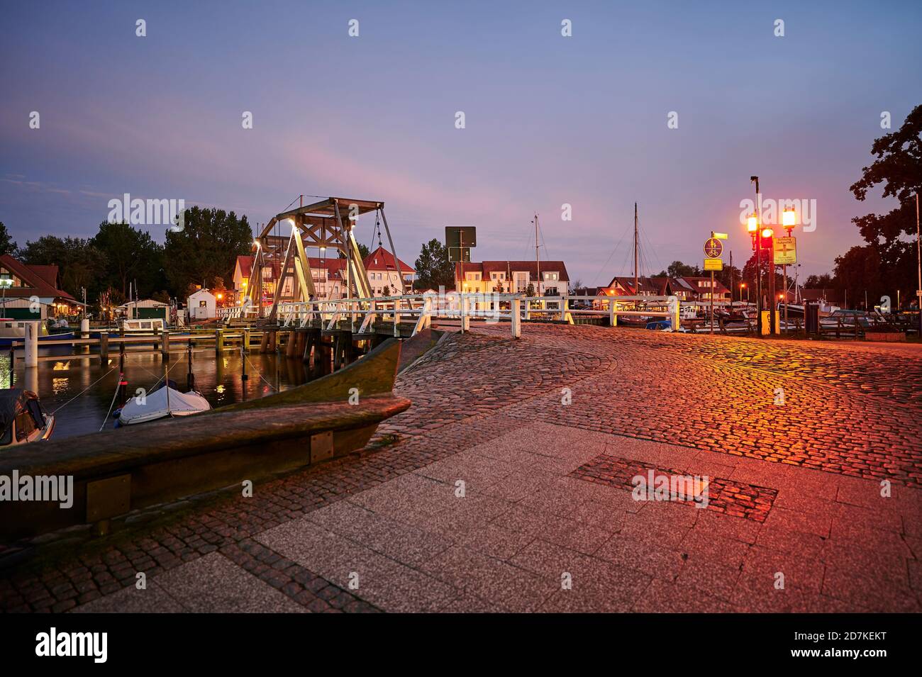 Greifswald, Deutschland - 30. August 2020: Blick auf den Greifswalder Segelhafen mit der historischen Bascule-Brücke und reflektierenden Lichtern zur blauen Stunde. Stockfoto
