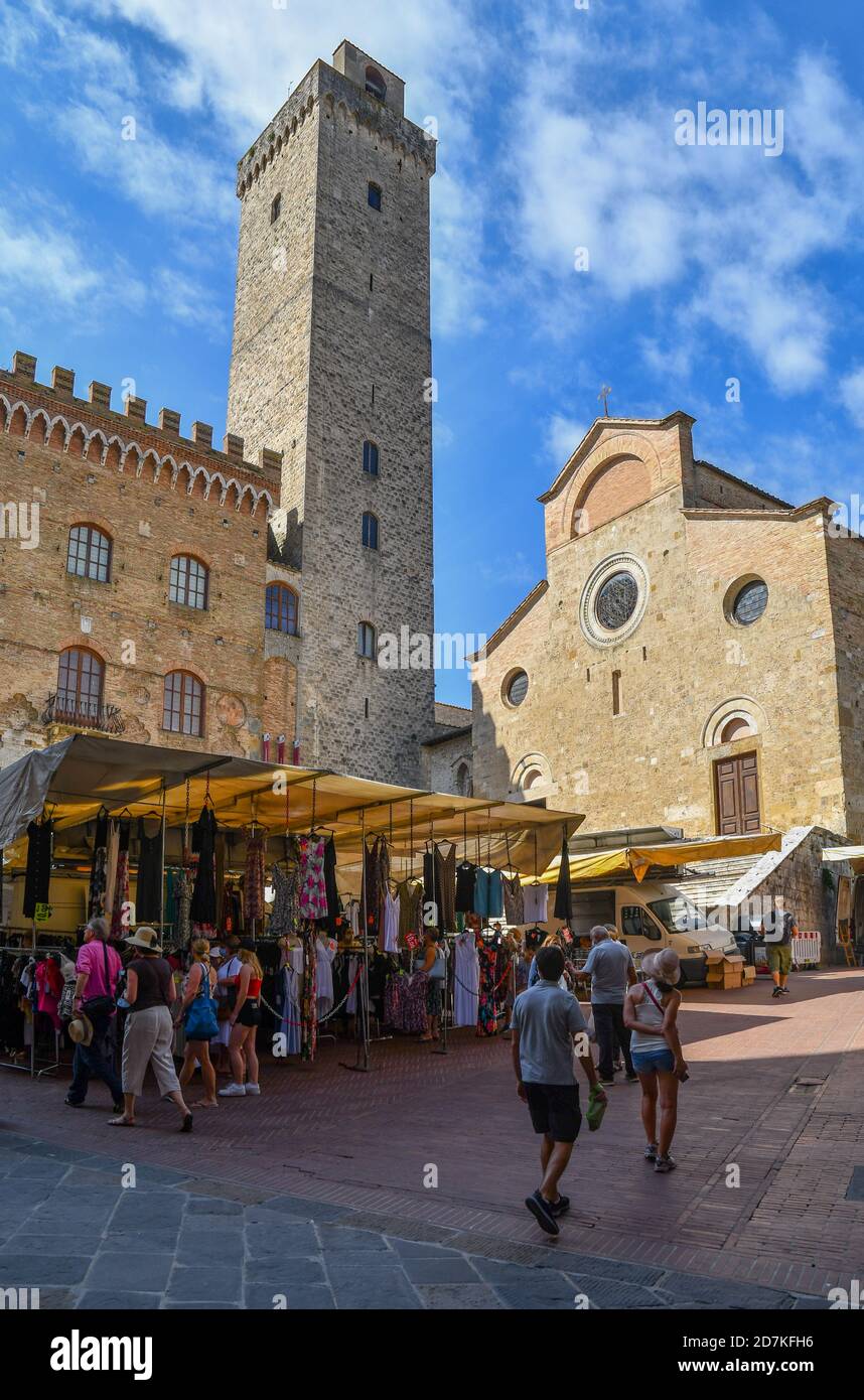 Piazza del Duomo mit dem Torre Grossa und der Kathedrale (Duomo) in einem Markttag mit Menschen und Touristen im Sommer, San Gimignano, Toskana, Italien Stockfoto
