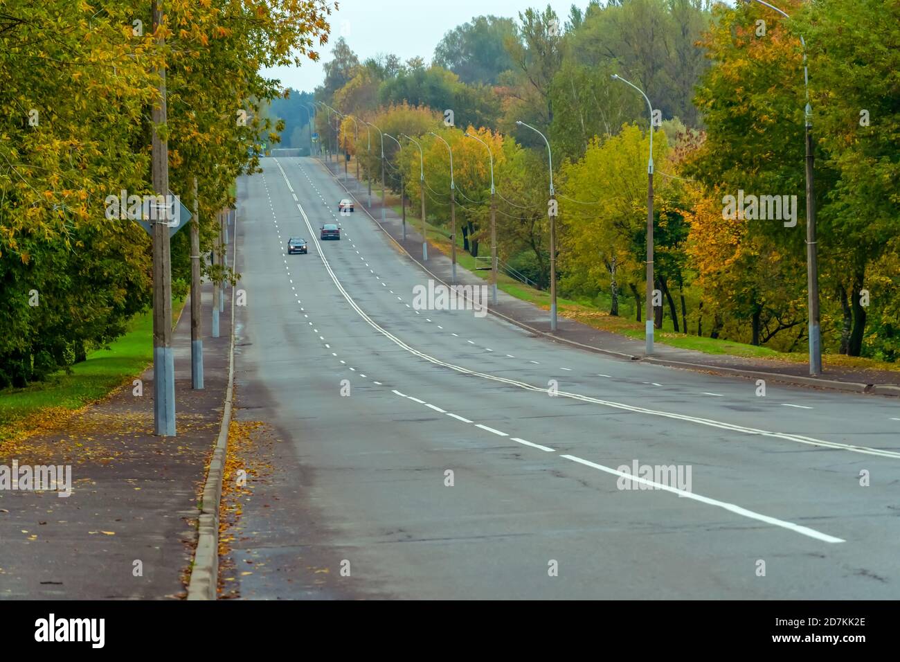 Vierspurige Autobahn mit einer kleinen Anzahl von Autos auf Ein wolkiger, farbenfroher Herbsttag Stockfoto