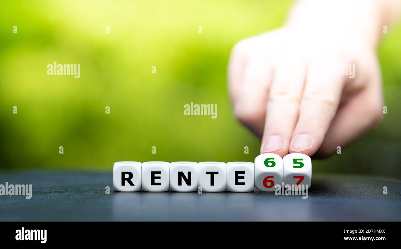 Hand dreht Würfel und ändert den deutschen Ausdruck "Rente 67" (Ruhestand 67) zu "Rente 65" (Ruhestand 65). Stockfoto