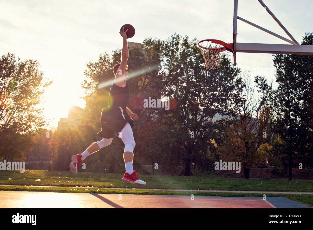 Junger Mann springen und eine fantastische Slam Dunk Streetball, Basketball zu spielen. Urbane verbindlich. Stockfoto