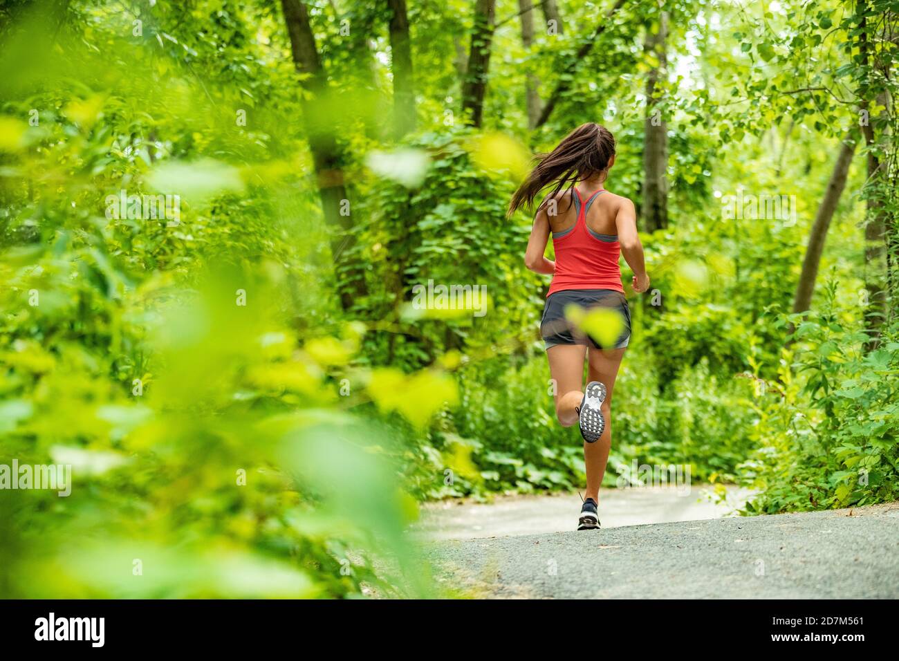 Gesunde aktive Lebensweise Frau Läuferin Joggen in Waldweg Sport Sportler Training im Freien in grüner Natur. Fit Person zu arbeiten. Stockfoto