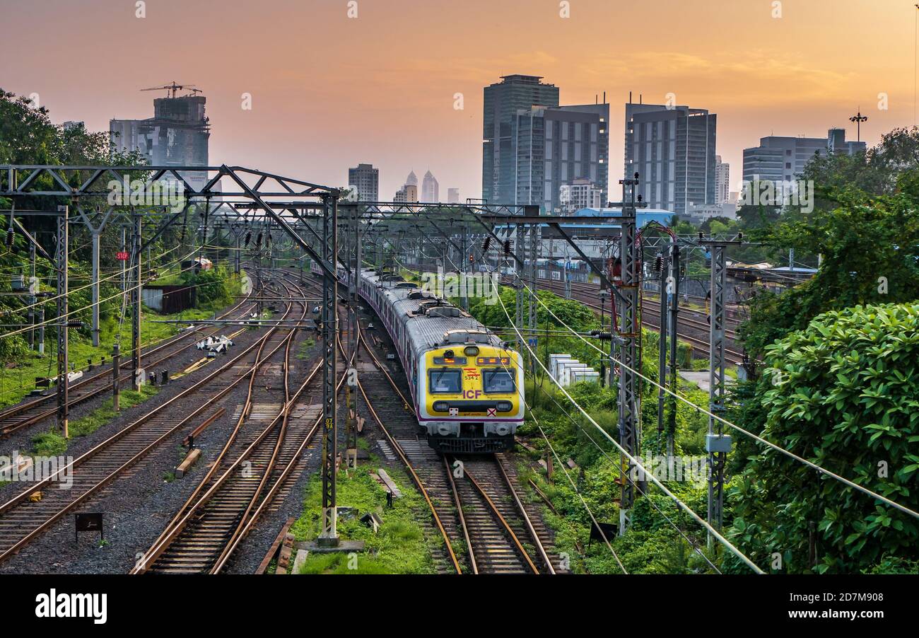 MUMBAI, INDIEN - 17. Oktober 2020 : Mumbai Suburban Railway, eines der verkehrsreichsten Pendlerbahnsysteme der Welt. Mumbai Stadtbild bei Sonnenuntergang mit Himmel Stockfoto