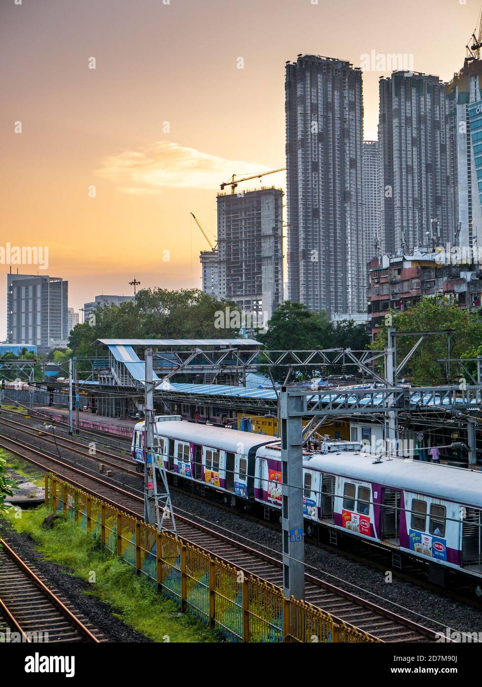 MUMBAI, INDIEN - 17. Oktober 2020 : Mumbai Suburban Railway, eines der verkehrsreichsten Pendlerbahnsysteme der Welt. Mumbai Stadtbild bei Sonnenuntergang mit Himmel Stockfoto