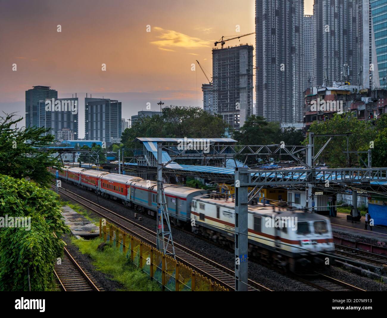 MUMBAI, INDIEN - 17. Oktober 2020 : Mumbai Suburban Railway, eines der verkehrsreichsten Pendlerbahnsysteme der Welt. Mumbai Stadtbild bei Sonnenuntergang mit Himmel Stockfoto