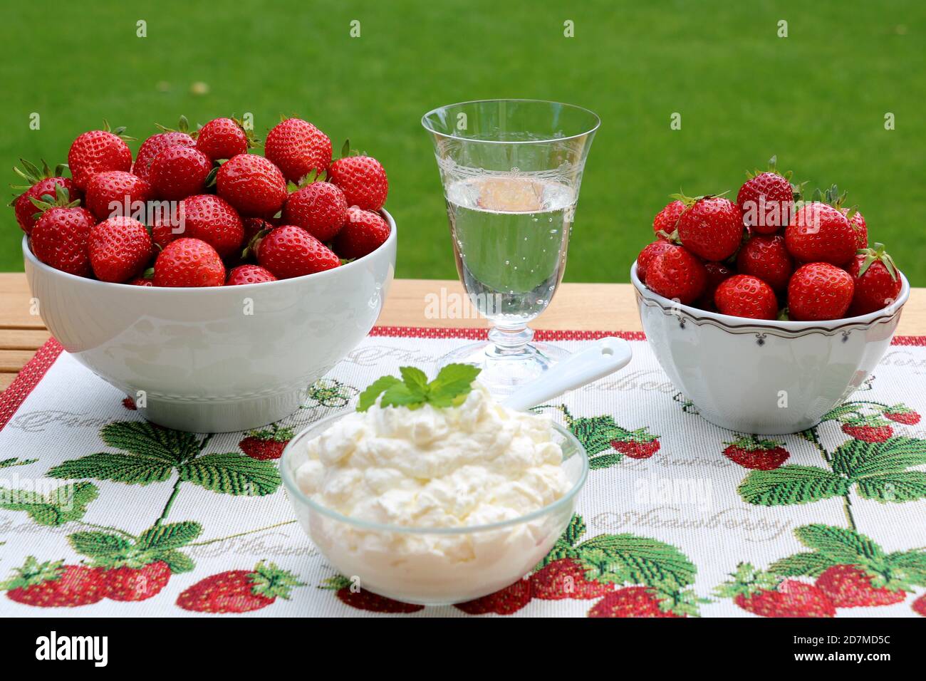 Frische Erdbeeren in Schüsseln und Schlagsahne Stockfoto