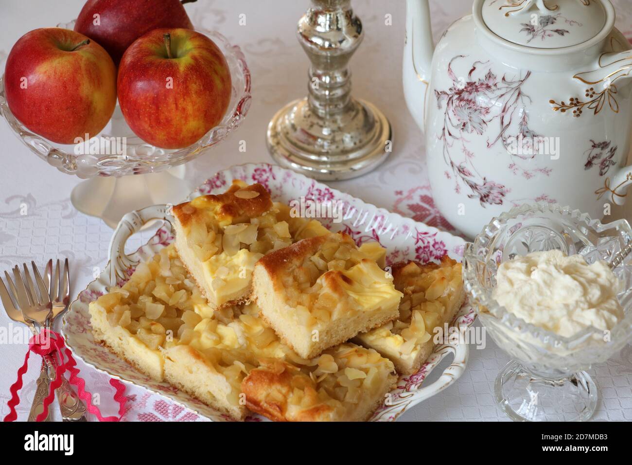 Tischdekoration mit Apfelkuchen, frischen Äpfeln und Kaffeekanne Stockfoto