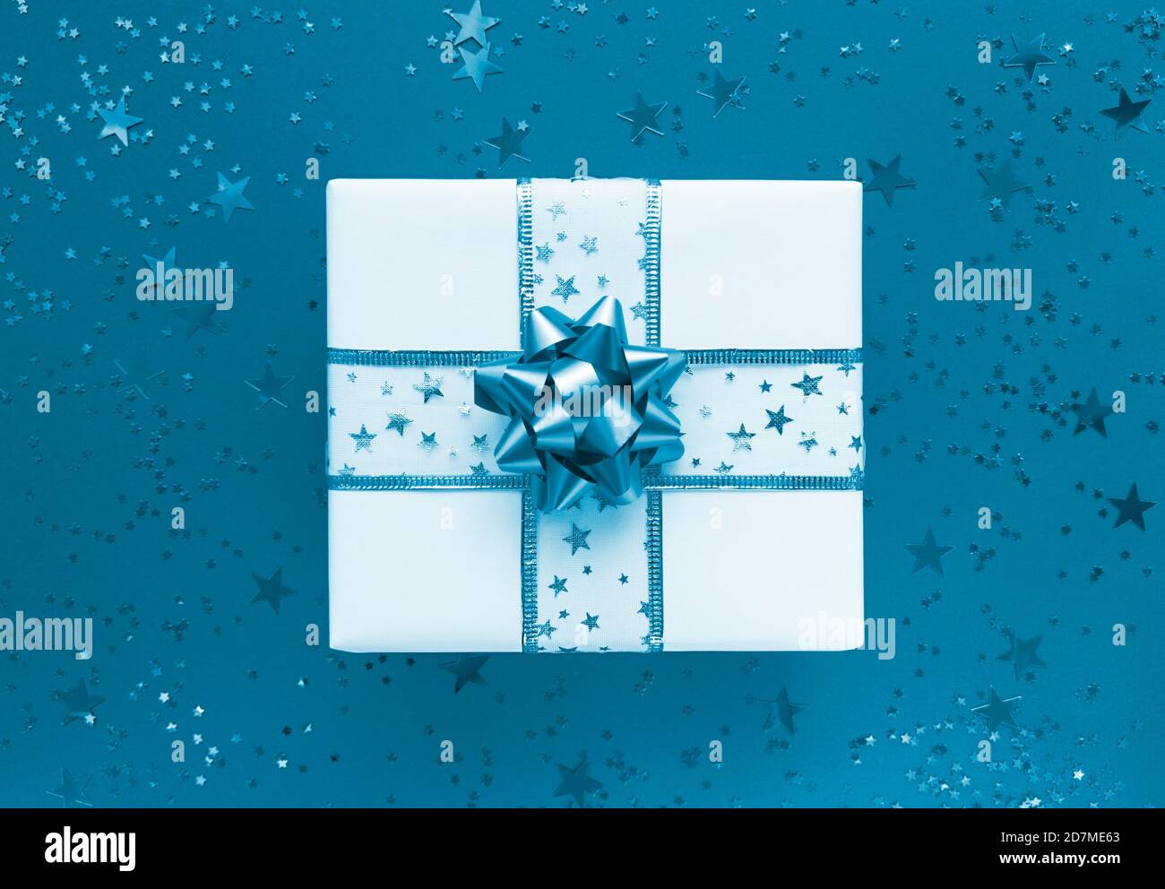 Geschenkbox und Sterne auf blauem Hintergrund. Monochrom flach liegend. Stockfoto