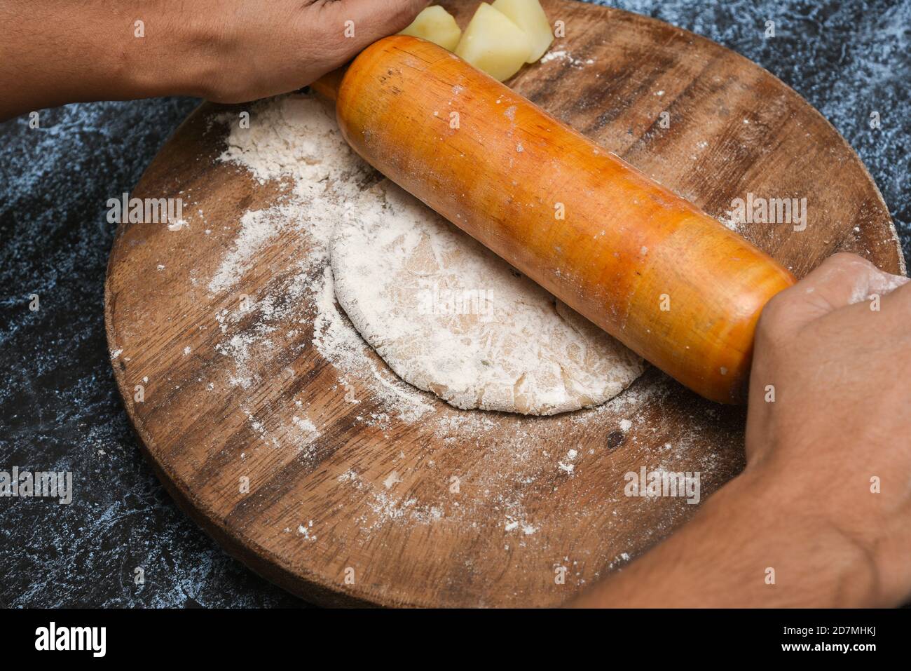 Vorbereitung von Aloo Paratha oder roti parantha chapati Punjab, Nordindien. Weibliche Hand Rollen Vollkornteig Kartoffelpüree mit Rollen Stockfoto