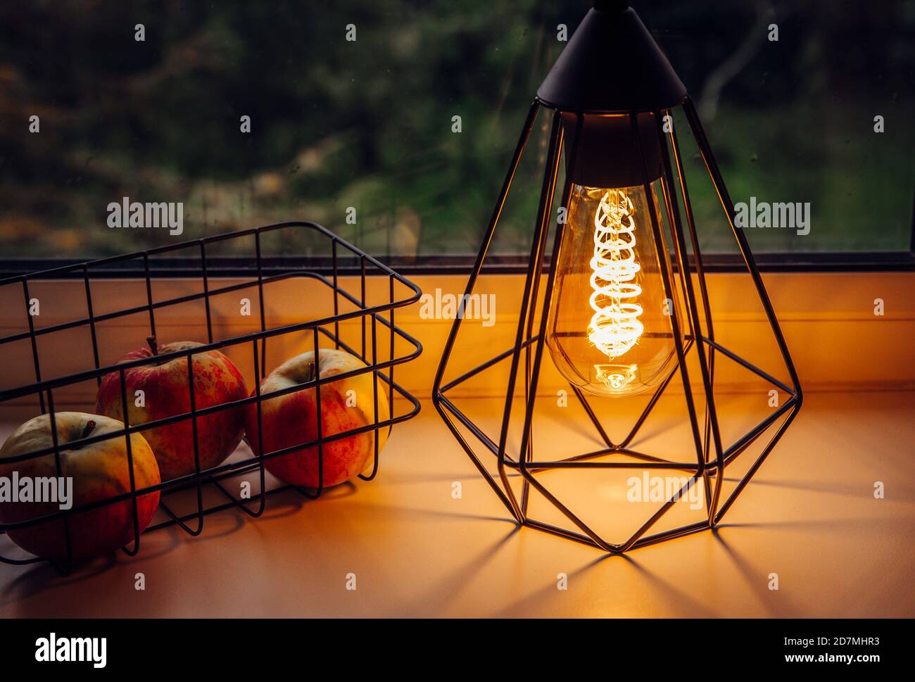 Moderne schwarze Draht-Lampe mit Spirallicht LED-Glühbirne beleuchtet und  Drahtkorb daneben. Moderne, gemütliche Einrichtung mit stimmungsvollem  Licht Stockfotografie - Alamy