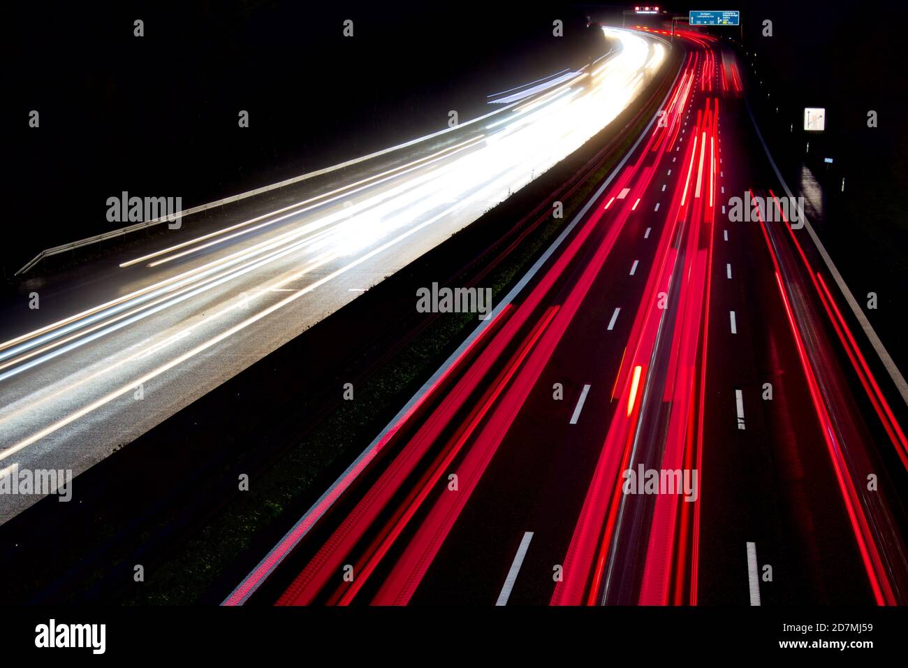 Autos bewegen sich schnell auf einer dunklen und nassen Autobahn Stockfoto