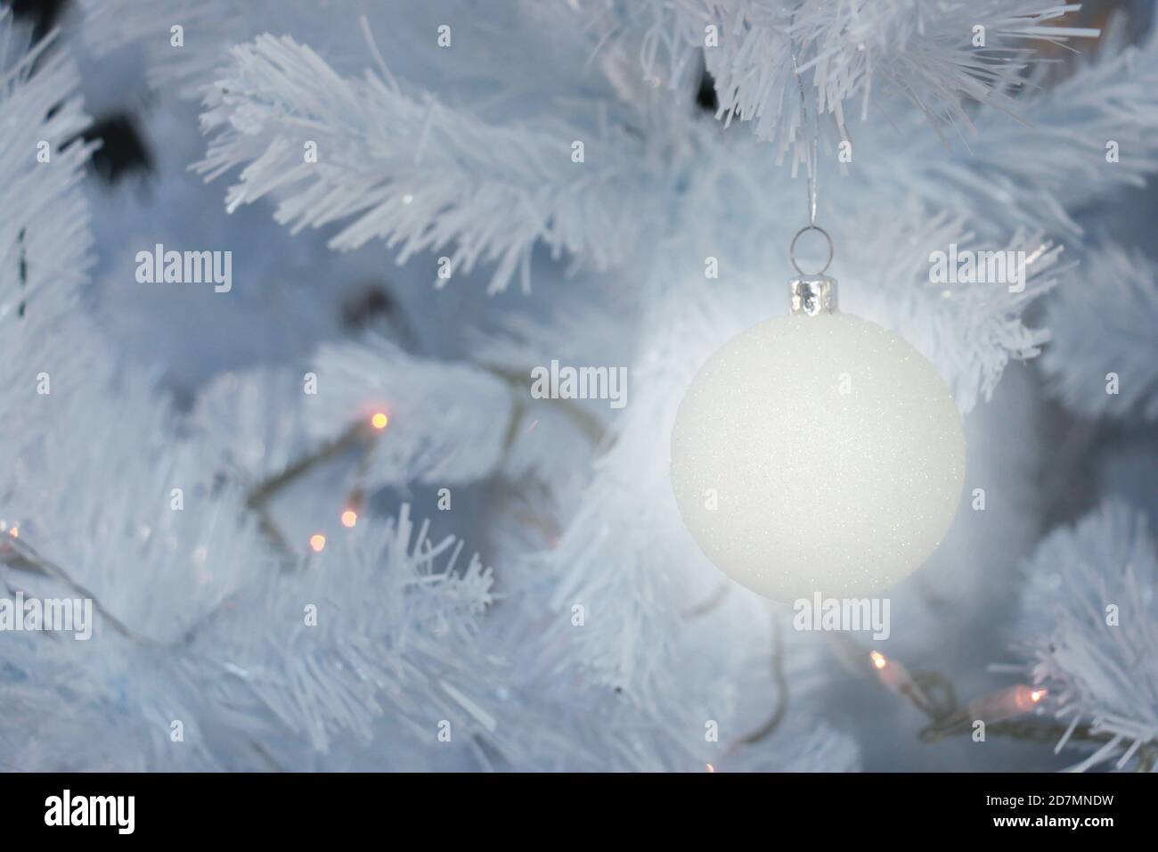 Eine Kugel-Glühbirne hängt auf weißem weihnachtsbaum Zur Feier der Saison Stockfoto