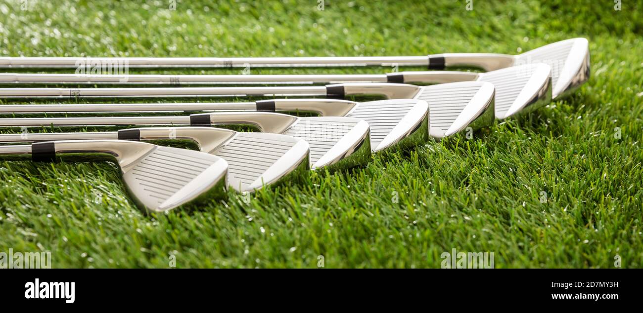Golfschläger auf grünem Golfplatz Rasen, Sonnenreflexionen, Nahaufnahme. Golf Sport und Ausrüstung Konzept, Banner. Stockfoto