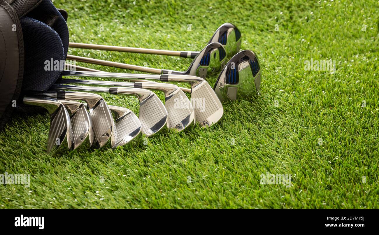 Golfschläger in einer Tasche auf grünem Rasen, glänzendem Edelstahl, Nahaufnahme. Golf Sport und Ausrüstung Konzept, Kopierer Raum. Stockfoto