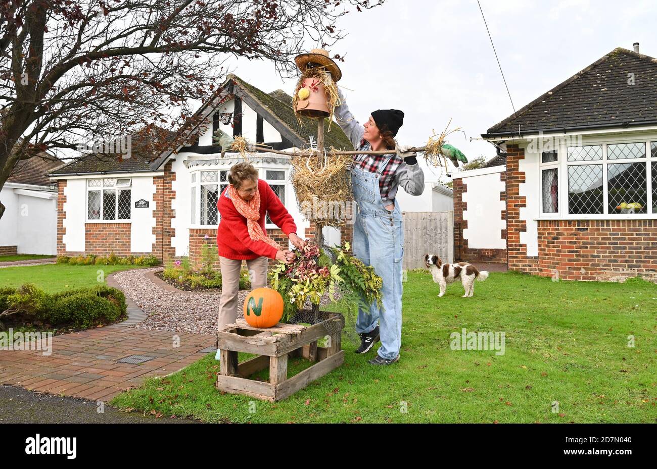 Worthing UK 24. Oktober 2020 - Pauline Ford und ihre Nichte Sophie fügen den letzten Schliff zu einer der hundert Vogelscheuchen, die rund um das Dorf Ferring in der Nähe von Worthing an diesem Wochenende erschienen sind, während ihr Scarecrow Festival findet diese Woche : Credit Simon Dack / Alamy Live News Stockfoto