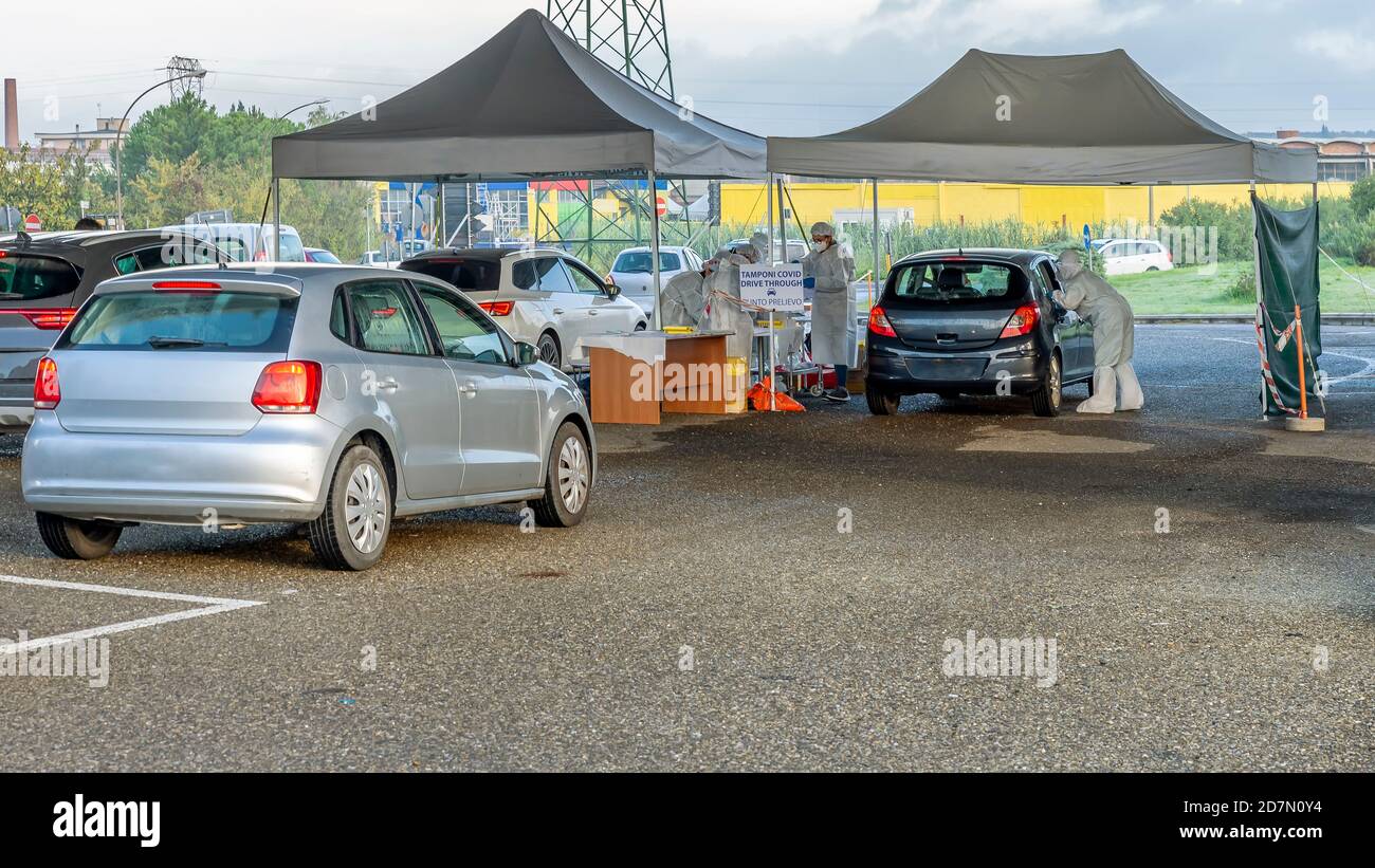 Zwei Reihen von Autos in der Warteschlange, warten auf den Testabstrich der möglichen covid-19 Coronavirus-Infektion in einer Fahrt mit zwei Pavillons, Empoli, Florenz Stockfoto