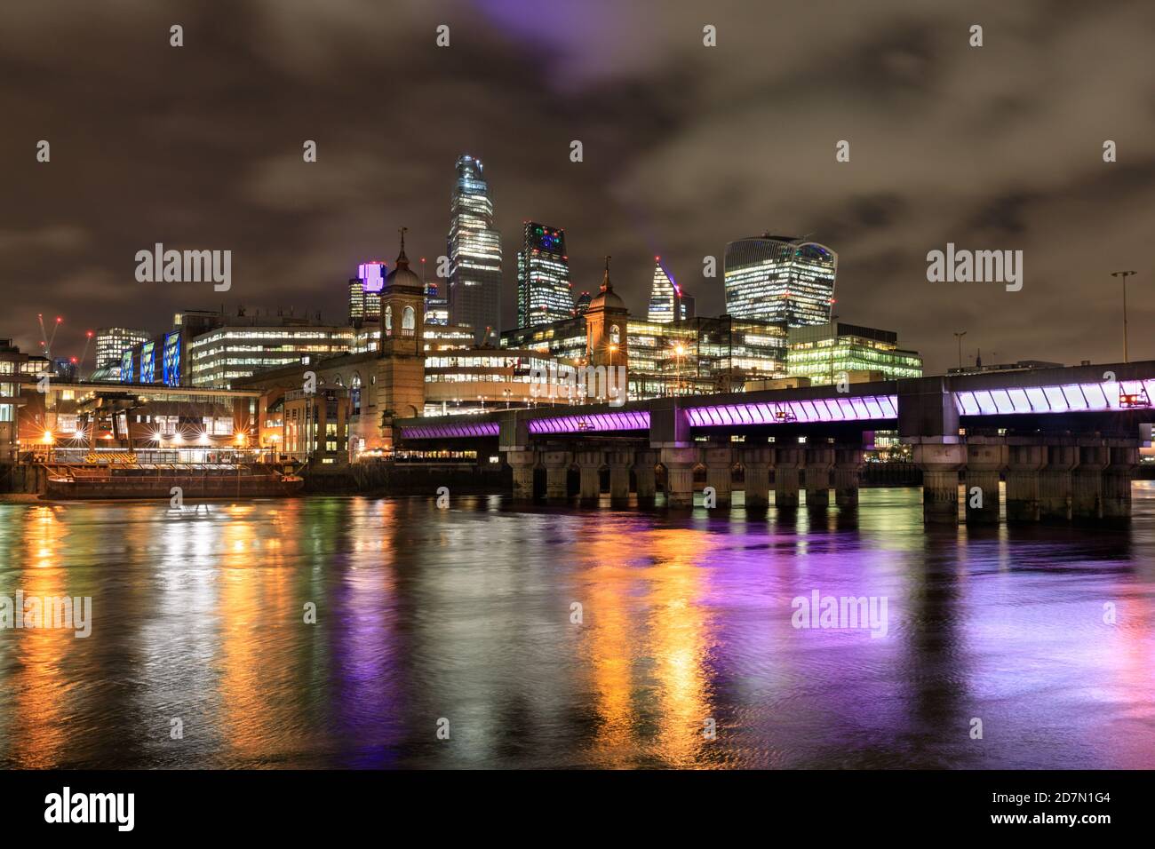 Blick über die Themse zu den beleuchteten City of London Wolkenkratzern bei Nacht, London, Großbritannien Stockfoto