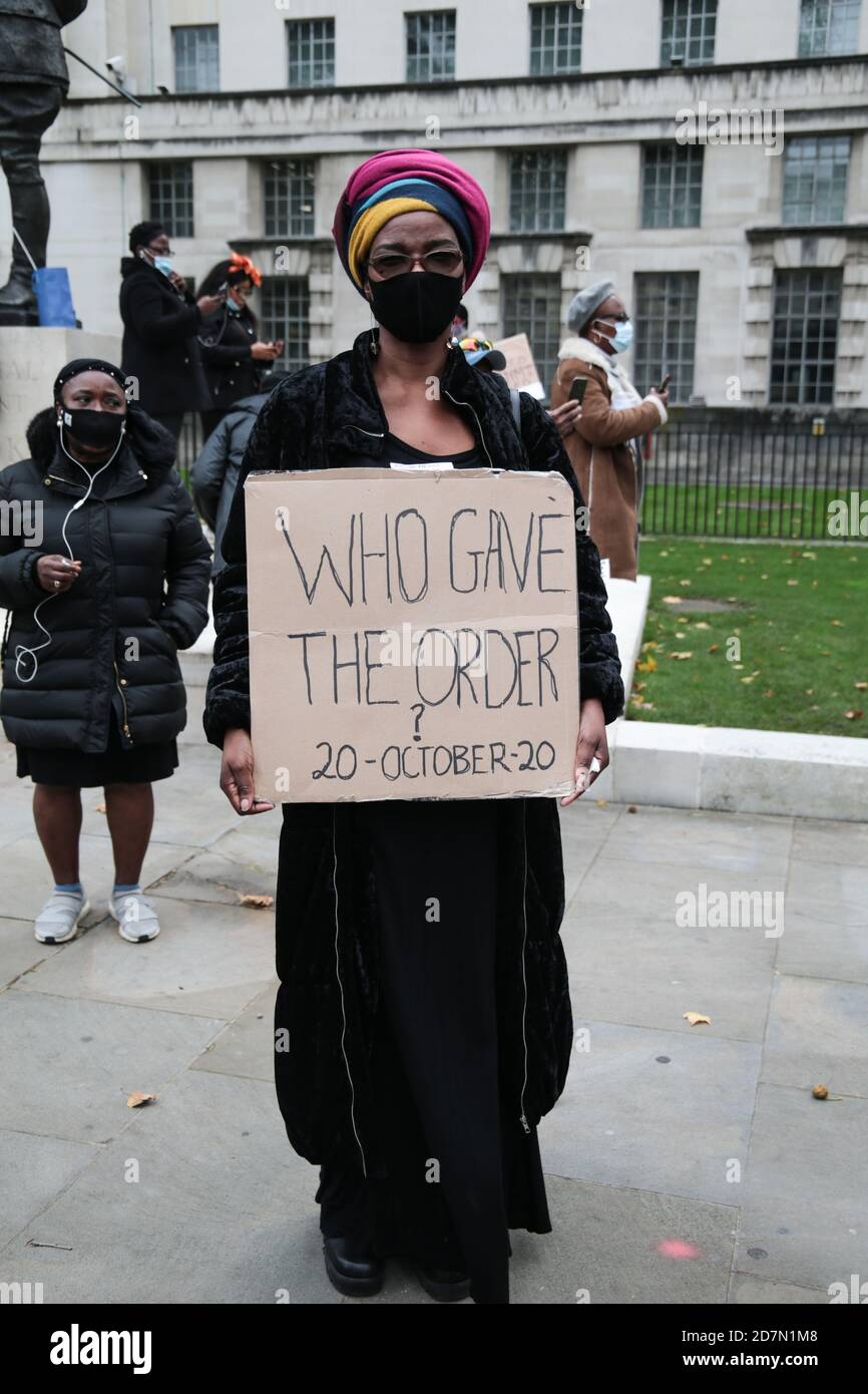 London UK 24 October 2020 Nigerianer versammelten sich in ihren Hunderten gegenüber Downing Street, um gegen die Regierung in Nigeria zu protestieren, die sie als korrupt ansehen und die Polizeibrutalität fördern, die in den letzten Monaten im Land eskaliert hat. Paul Quezada-Neiman /Alamy Live News DEMONSTRANTEN mit Plakat, das an die Ereignisse in Lagos erinnert in der Nacht des 20. Oktober 2020 schossen die nigerianischen Streitkräfte auf unbewaffnete Demonstranten am Mauttor von Lekki in Lagos, Nigeria. Laut Amnesty International wurden kurz vor den Dreharbeiten CCTV-Kameras angeblich entfernt Stockfoto