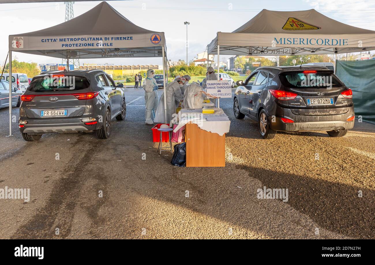 Zwei Reihen von Autos in der Warteschlange, warten auf den Testabstrich der möglichen covid-19 Coronavirus-Infektion in einer Fahrt mit zwei Pavillons, Empoli, Florenz Stockfoto