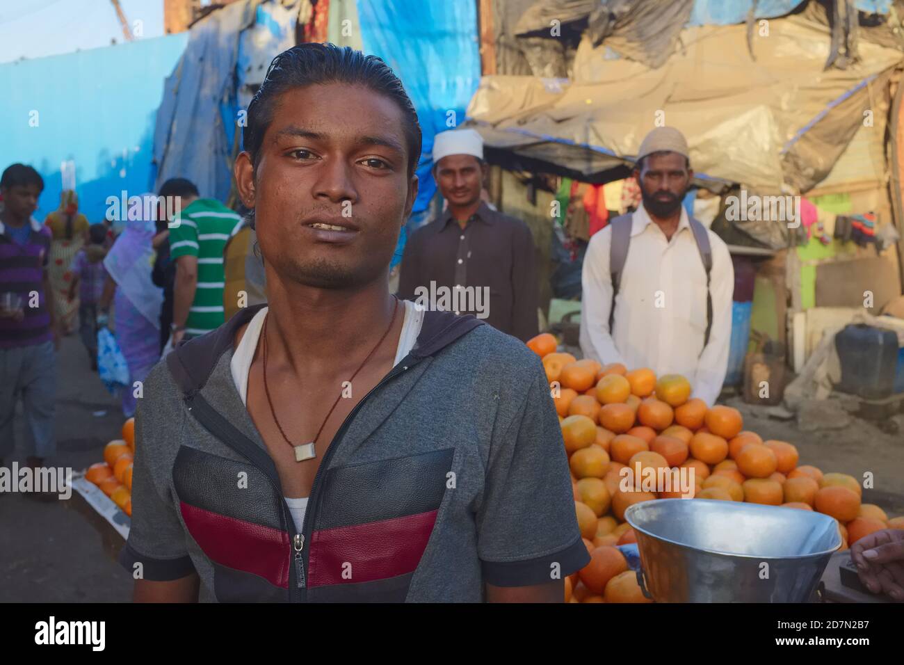 Porträt eines orangenen Verkäufers vor seinem Handkarren in einer belebten Gasse muslimisch dominierten Darukhana Slum Area, Mazagaon (Mazgaon), Mumbai, Indien Stockfoto