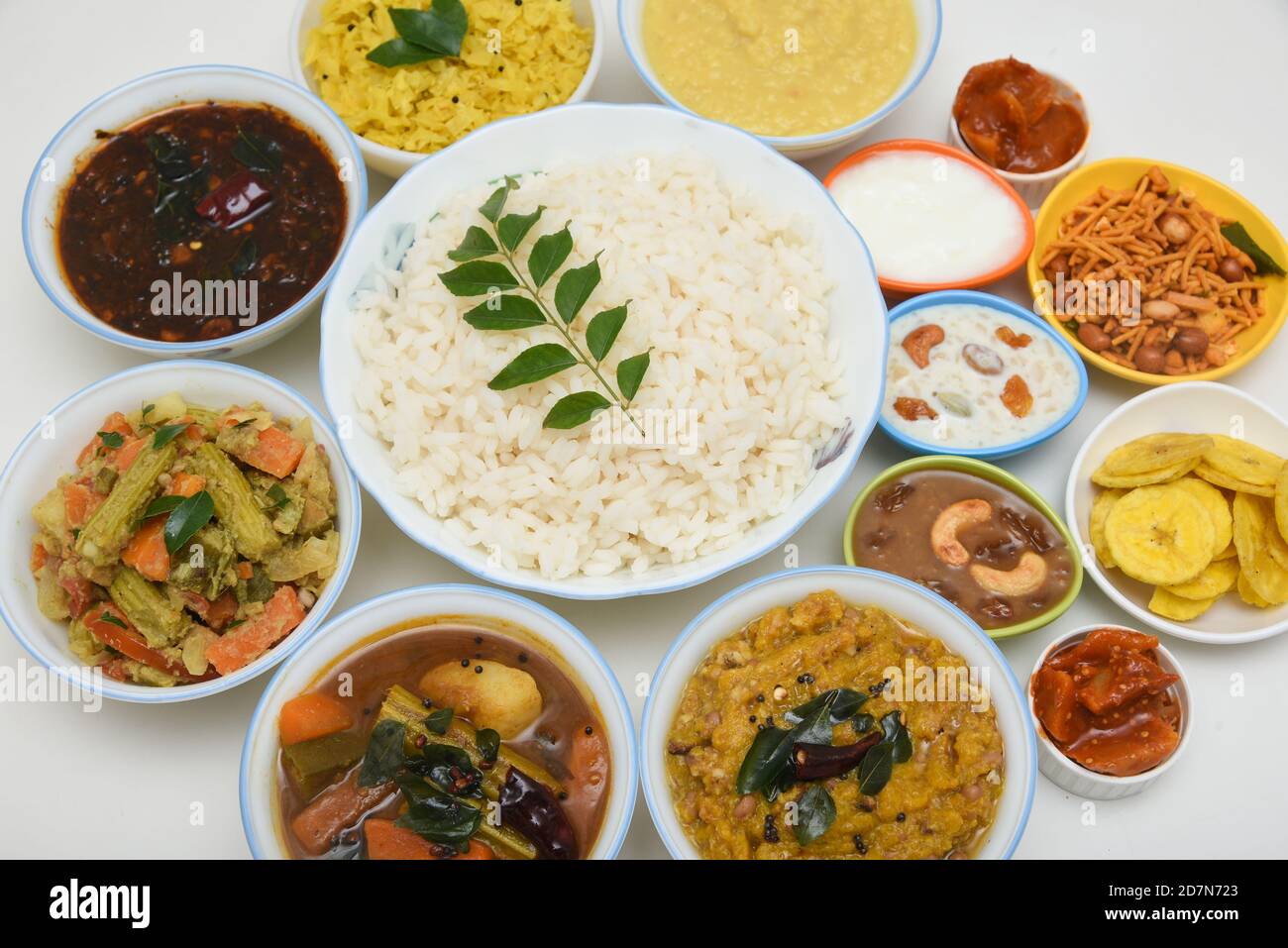 Onam sadhya, indische Frauen essen mit Hand gekochten Reis, serviert für Kerala Indian Festival mit Curries Sambar, Avial, Thoran, Papadum, Payasam, Banana Stockfoto