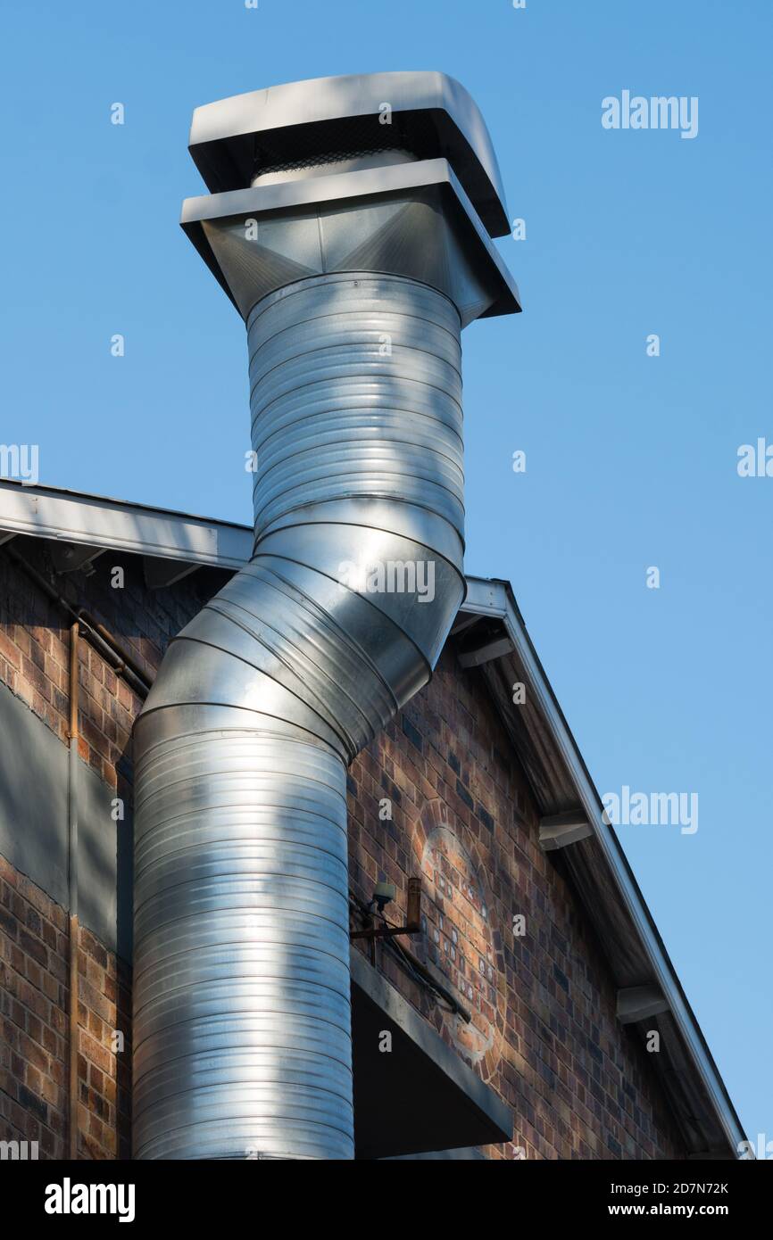 Stahl freistehender Kamin gegen ein Ziegelgebäude Konzept Industrie Ausrüstung Stockfoto