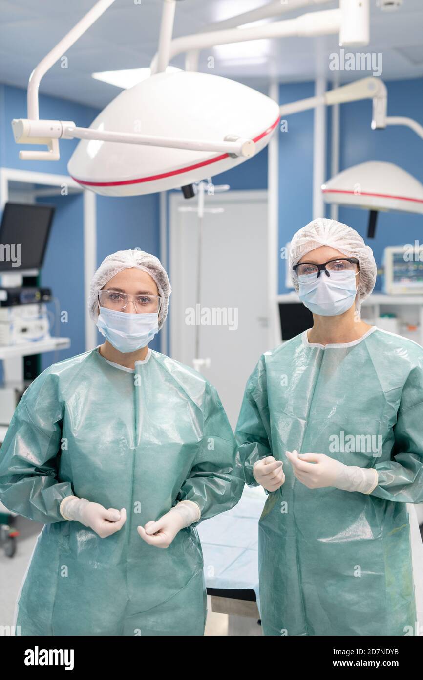 Zwei junge professionelle Chirurgen in schützenden Arbeitskleidung Vorbereitung für die Operation Stockfoto