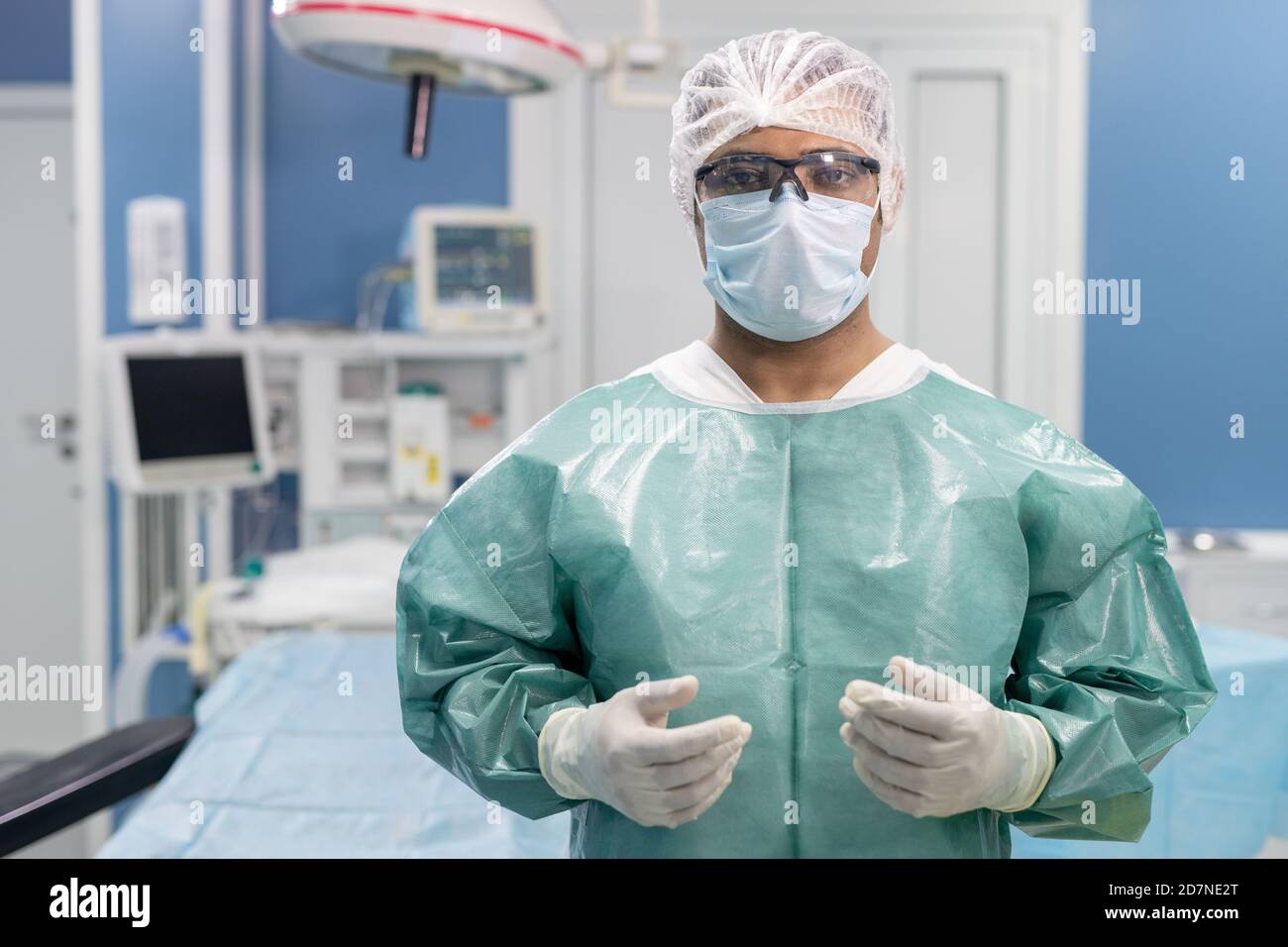 Erfolgreicher männlicher Chirurg, der Sie gegen medizinische Geräte in Kliniken Stockfoto