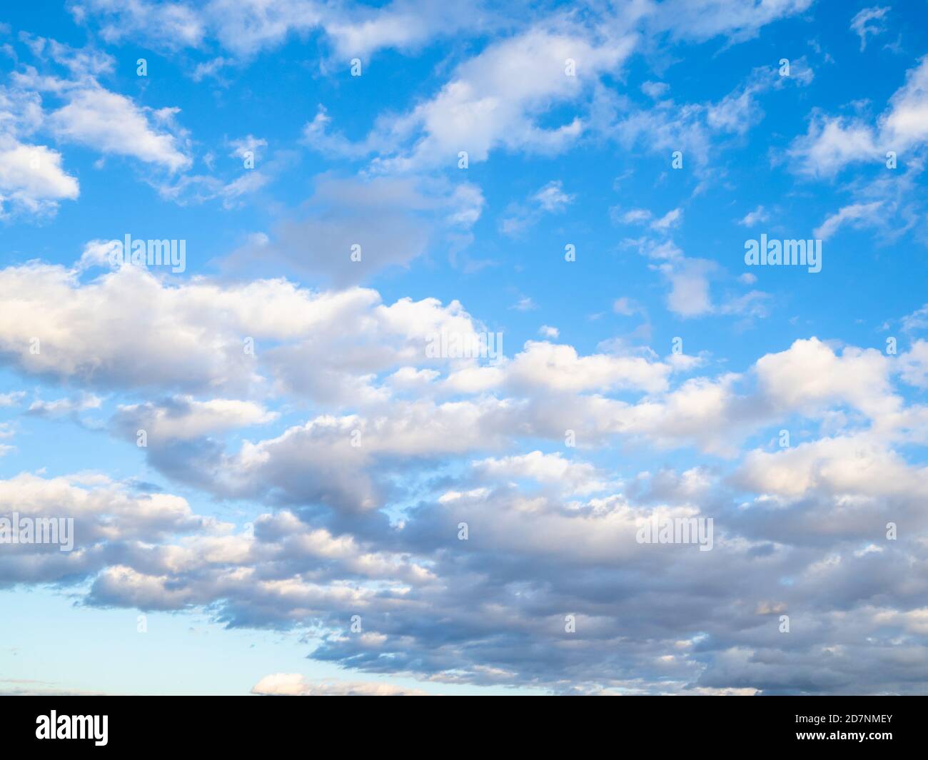 Viele niedrige Wolken am blauen Himmel am sonnigen Herbsttag Stockfoto