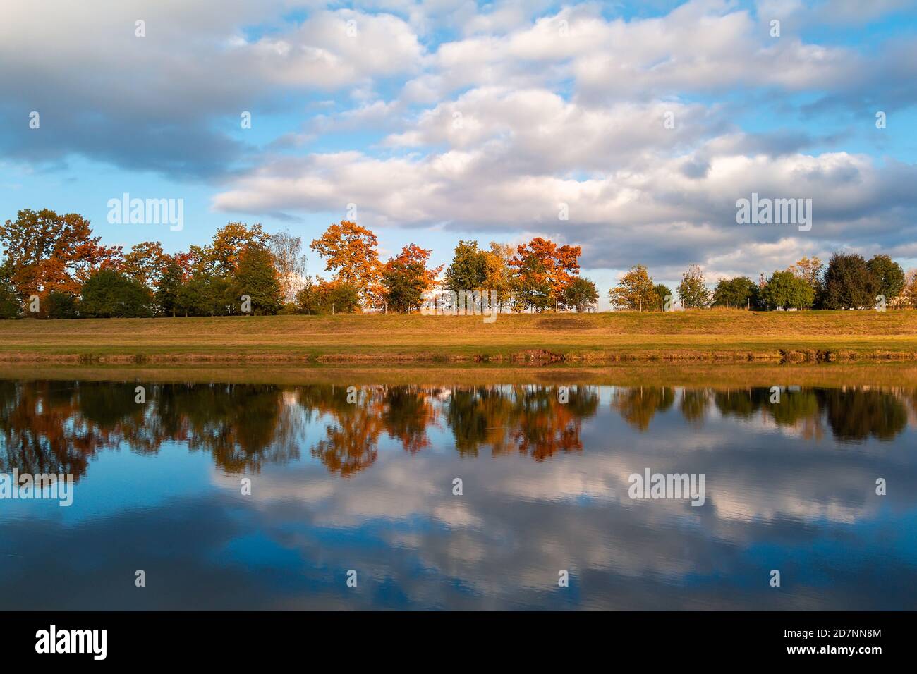 Herbst farbenfrohe Laub Blätter Bäume in Moldau mit bewölktem blauen Himmel reflektiert. Tschechische Landschaft Stockfoto