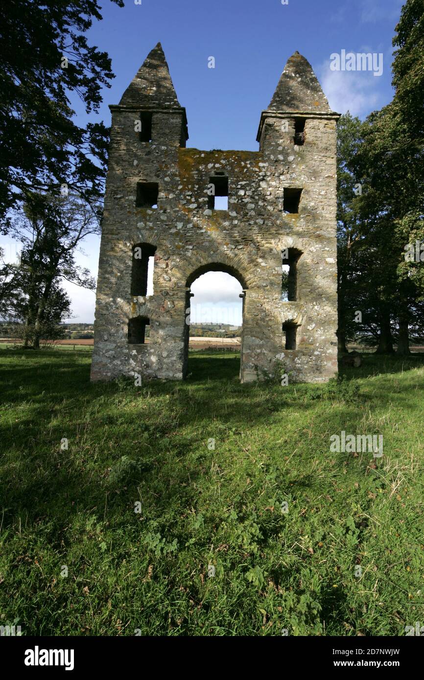 Grenzt an den Hunty Mundy im Mellerstain House bei Kelso. Hundy Mundy Tower, Tower in Melrose, Schottland, Großbritannien. Eine Torheit, die nach einer Prinzessin benannt wurde, die Körper in einer natürlichen Waldbestattung überblickt.Eine gotische Torheit, die zur Vervollständigung der entworfenen aussicht, die sich südöstlich von Mellerstain in den schottischen Grenzen erstreckt, gebaut wurde, befindet sich Hundy Mundy in einer spektakulären Lage, eine Meile (1,5 km) nordöstlich von Smailholm und 5 Meilen (8 km) Nordwestlich von Kelso. Es wurde 1726 begonnen und besteht aus einem hohen Torbogen zwischen quadratischen Türmen, die von Pyramiden bedeckt sind, und war das Werk von William Adam (1689 - 1748), der der Architekt gewesen war Stockfoto