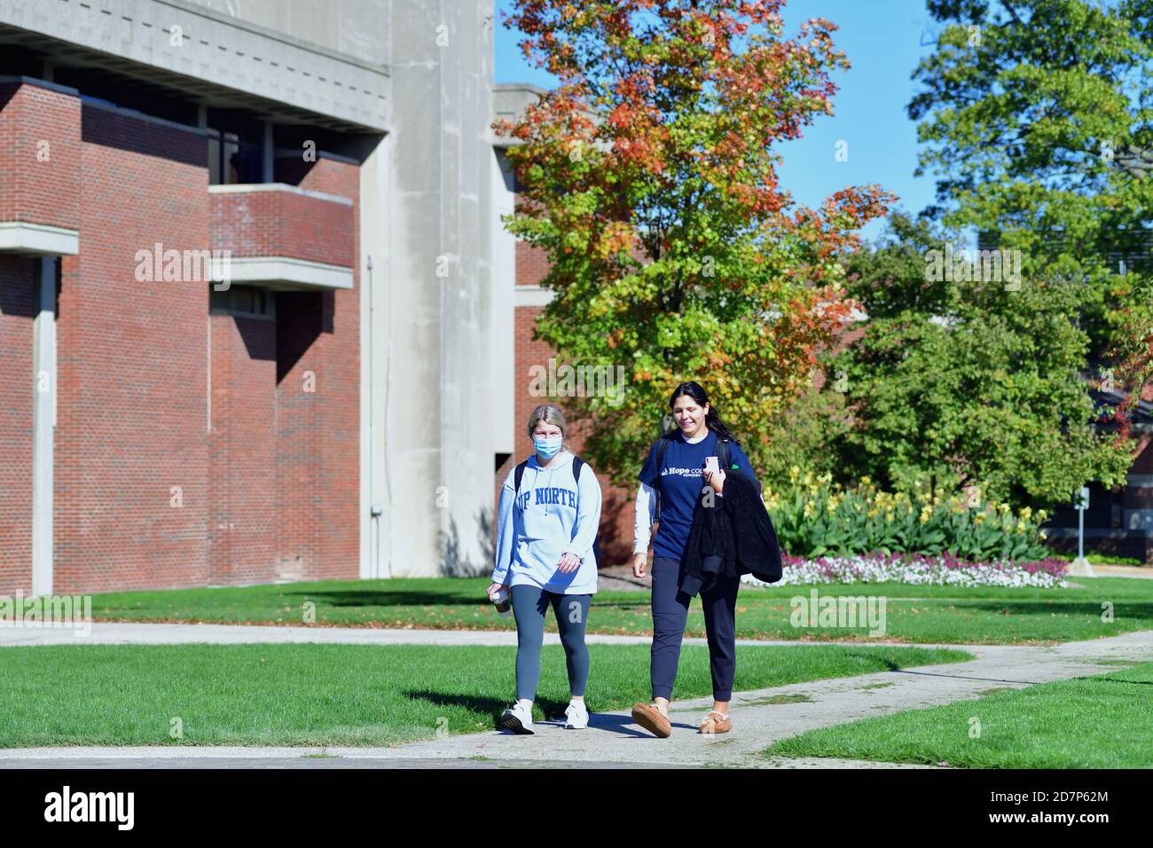 Holland, Michigan, USA. Zwei Studenten, die im Herbst nach der COVID-19-Pandemie in den Vereinigten Staaten auf dem Campus des Hope College unterwegs waren. Stockfoto