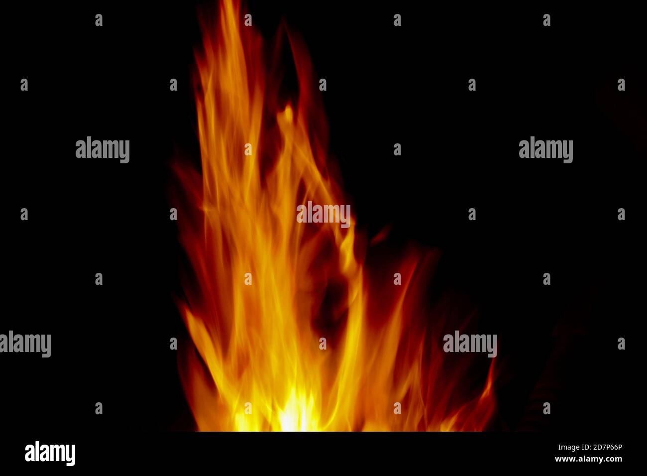 Leuchtend goldorange Flammen vor schwarzem Hintergrund mit Kopierraum Stockfoto